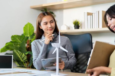 Modern ofis ortamında profesyonellerin yer aldığı sürdürülebilirlik için ESG stratejileri üzerine odaklanmış bir tartışma.