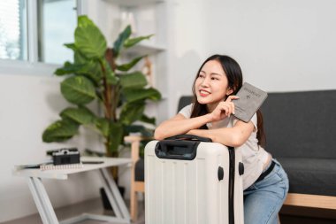 Neşeli bir gezgin, pasaportunu valizinin yanında sergiliyor, heyecanlı bir yolculuğa hazır..