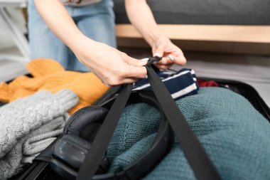 Düzenli bir şekilde bir bavula giysi ve gerekli şeyleri koyarak seyahate hazırlanmak, seyahat hazırlığı ve organizasyonu sergilemek..