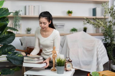 Bir kadın, bir masanın üzerinde kitap organize eder. Taşınan yolculuğunda organizasyonun ve hazırlığın önemini vurgular..