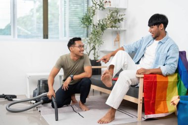 Birbirine eşlik eden iki genç adam ev işlerini yapıyor. Canlı bir eve dostluk, işbirliği ve kapsayıcılık sahnesi..