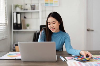 Renk örnekleriyle dolu canlı bir çalışma alanı, tasarımcının bir sonraki sanat projesi için paletleri dikkatle seçtiği ve düzenlediği yer..