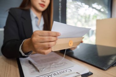 Bir kadın avukat, ileriki müzakereler ve istişareler için hazırlanan önemli yasal belgeleri dikkatle yönetir ve inceler..