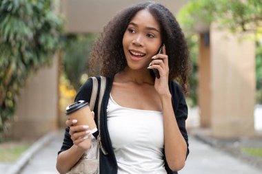 Bir kadın, sürdürülebilir kahve seçimiyle geliştirilmiş neşeli bir anı gösteren canlı bir telefon konuşmasından hoşlanır..