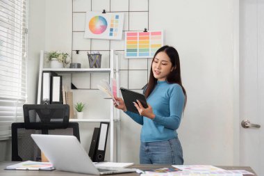 Bir tasarımcı seçilen renk örneklerini hevesle paylaşarak, yaklaşan bir proje için uyumlu bir renk karışımı gösterir.