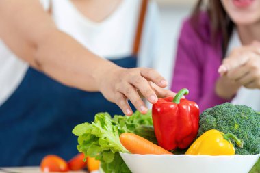 Canlı sebzeler seçen, yemek pişirmenin ve sağlıklı beslenmenin zevkini gösteren yakın plan bir fotoğraf..