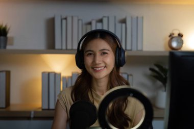 Neşeli bir kadın, izleyicileriyle canlı yayında iletişim kuruyor, uzaktan çalışmanın ve dijital etkileşimin geleceğini gösteriyor..