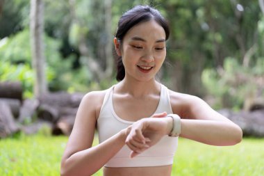 Genç bir kadın spor yaptıktan sonra spor yaparken spor yaparken gülümsüyor. Formunun gelişimini yansıtıyor..