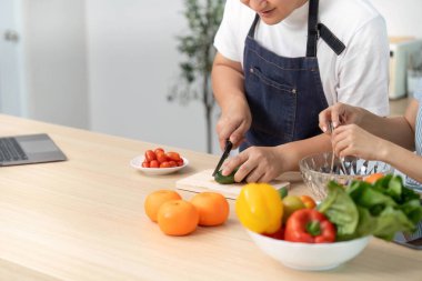 Bir çift, sağlıklı yemek ve takım çalışmasını vurgulayarak, modern bir mutfakta taze sebze ve meyve hazırlıyor. Refah temaları için mükemmel.