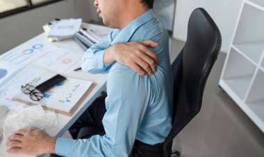 Çağdaş bir ofiste omuz ağrısıyla uğraşan bir iş adamının mücadelesini araştırın..