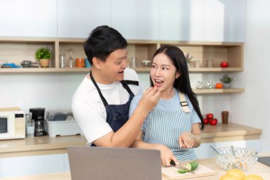 Bir çift birlikte yemek yapmaktan, taze malzemeler paylaşmaktan ve modern mutfaklarında kahkaha atmaktan hoşlanır..