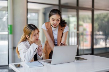 Modern ofis ortamında, ortaklık ve yeniliğe odaklanmış iki iş adamı ortak bir tartışma içindeler..