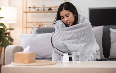 Bir insanın battaniyeye sarılı olduğu bir yalnızlık anı sıcak bir oturma odasında kendini kötü hissetmesini yansıtır..