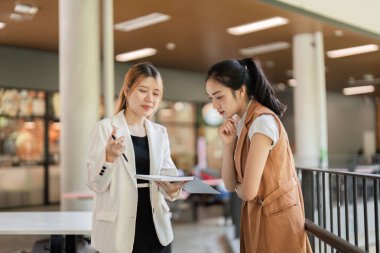 İki iş kadını, modern bir ofis ortamında stratejik planlar üzerine danışmanlık yaparak ortak bir tartışmaya giriştiler..