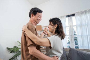 Emekli bir çift, altın yıllarında aşk ve mutluluğu kutlamak için oturma odalarında neşeli bir dans eder..