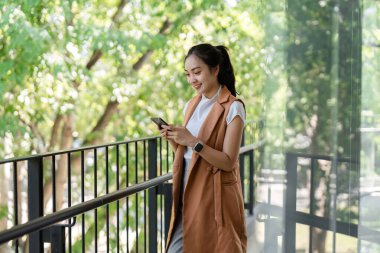 İş kadını, borsa eğilimlerini analiz etmek, modern teknoloji ve finansmanı sergilemek için akıllı telefon kullanıyor..