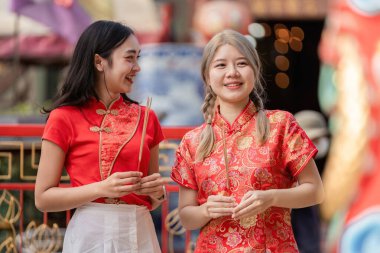 İki arkadaş Çin 'in yeni yılını canlı geleneksel kıyafetleriyle kutluyor neşe ve şenlik ruhunu canlı bir sokak ortamında paylaşıyorlar..