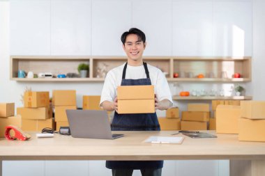 Genç bir girişimci, e-ticaret işini yönetirken sevinç ifadesi sergiliyor..