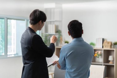 İki meslektaş proje detaylarını tartışıyor, kurumsal bir ortamda etkili iletişim ve işbirliği sergiliyorlar.