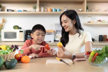 Bir anne ve oğlu eğlenceli bir aktiviteye girişiyor, renkli sebzeleri birlikte keşfediyor, sağlıklı beslenmeyi ve aile etkileşimini destekliyor..