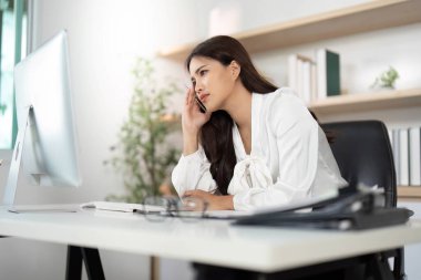 Genç bir kadın, uzak çalışma sırasında stresle başa çıkarken hayal kırıklığı içinde başını tutuyor. Ruh sağlığı ve iş hayatı dengesi kavramı.