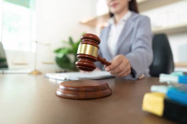 Bir iş kadını, yasal konularda otorite ve nihai temsil eden bir tokmağa kendinden emin bir şekilde vurur..