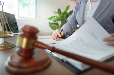 Bir iş kadını, resmi anlaşmaların hukuktaki önemini vurgulayan yasal bir belgeyi inceler ve imzalar.