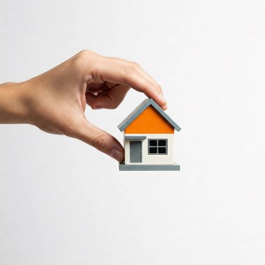 Küçük bir oyuncak evi, beyaz bir arka planda izole edilmiş..