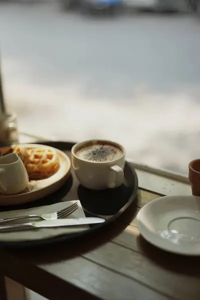 Cappuccino kahve fincanı ve çatal ve bıçaklı waffle..