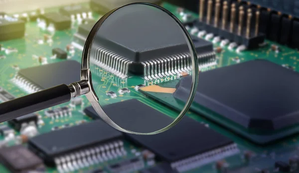 view of printed circuit board with active and passive surface mounted components close up through magnifying glass