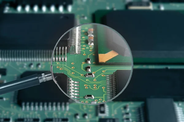 view of printed circuit board with active and passive surface mounted components close up through magnifying glass