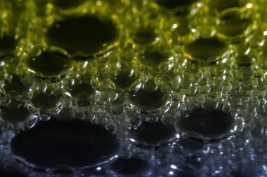 Su yüzeyindeki yağ damlacıklarının ve baloncukların makrofotografı