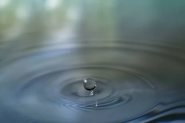 Clear aqua water droplet splashing in concentric circles, capturing refreshing purity.