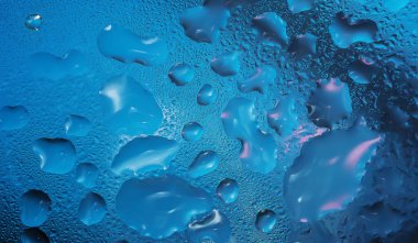 Camdan bir yüzeye su damlıyor. Yaklaş.