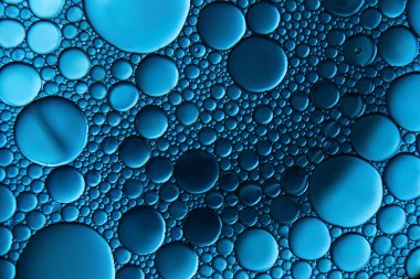 Su yüzeyindeki yağ damlacıklarının ve baloncukların makrofotografı