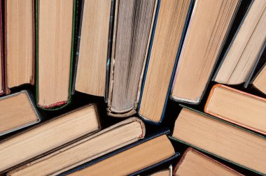 Koyu arkaplan ve üst görünüm üzerine birçok farklı ciltli eski kitap