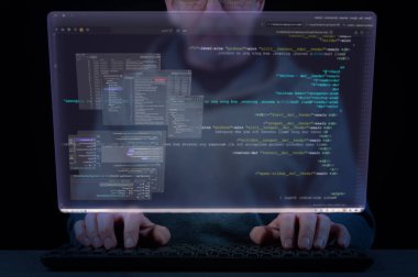 Bir adamın elleri klavyede ve yazılım geliştirme sisteminin pencereleri olan sanal ekranda. Yazılım geliştirme, kodlama, programlama ve test kavramı
