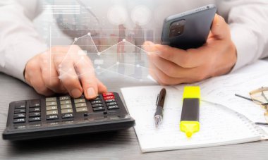 Harcamaların hesaplanması ve profesyonel bir çalışma alanındaki finansal verilerin analiz edilmesi ve yakınlardaki notların ve kırtasiyelerin referans alınması.