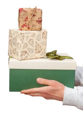 Bir el, her biri zarif tasarımlarla süslenmiş, bayram kutlamalarına hazır üç hediyeyi tutuyor..