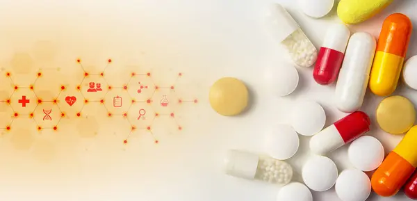 Değişik renk ve boyutlarda çeşitli kapsüller ve tabletler yumuşak mavi bir ışıltıyla geliştirilmiş pürüzsüz bir yüzeye saçılmıştır..