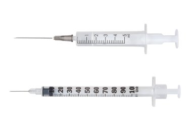 İki şırınga, biri kesin ilaç dozları için tasarlanmış, temiz ve iyi aydınlatılmış bir tıbbi ortamda kullanıma hazır bekliyor..