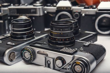 Çeşitli kullanılmış film kameraları ve deri çantaların toplanması, analog fotoğraf ekipmanlarının zamansız cazibesini ve zanaatkarlığını gözler önüne sermektedir..
