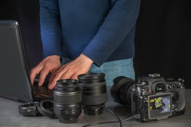 Kamera lensleri ve DSLR ile çevrili bir dizüstü bilgisayar kullanarak yeni bir fotoğraf projesine hazırlanan yaratıcı profesyonel kurgu görüntüleri.