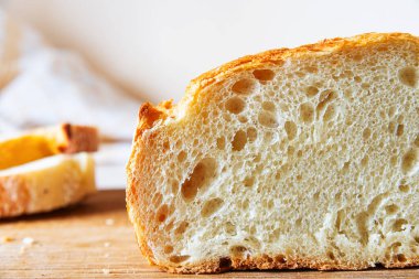 Dilimlenmiş zanaat ekmeği havadar iç ve altın kabuğunu sergiliyor, tazeliğini ve kalitesini vurguluyor..