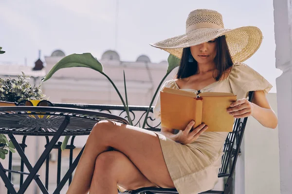 Молодая Женщина Элегантной Шляпе Читает Книгу Отдыхая Балконе — стоковое фото