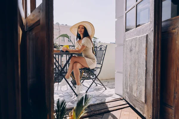 Красивая Молодая Женщина Элегантной Шляпе Наслаждается Горячим Напитком Расслабляясь Балконе — стоковое фото