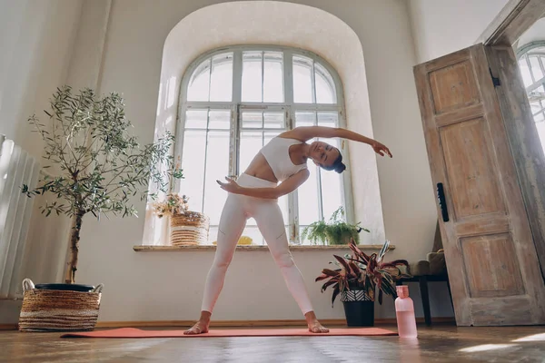 Concentrato Giovane Donna Facendo Esercizi Stretching Durante Pratica Casa — Foto Stock