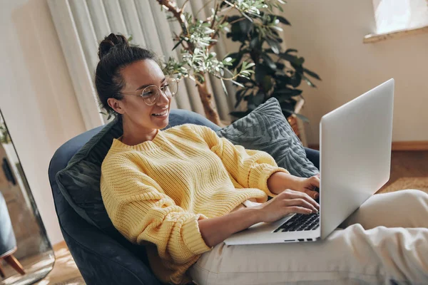 Αυτοπεποίθηση Νεαρή Γυναίκα Χρησιμοποιώντας Φορητό Υπολογιστή Και Χαμογελώντας Ενώ Κάθεται — Φωτογραφία Αρχείου