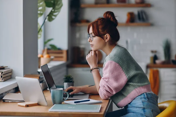 Koncentrerad Ung Kvinna Använder Laptop När Sitter Vid Köksbänken Hemma — Stockfoto