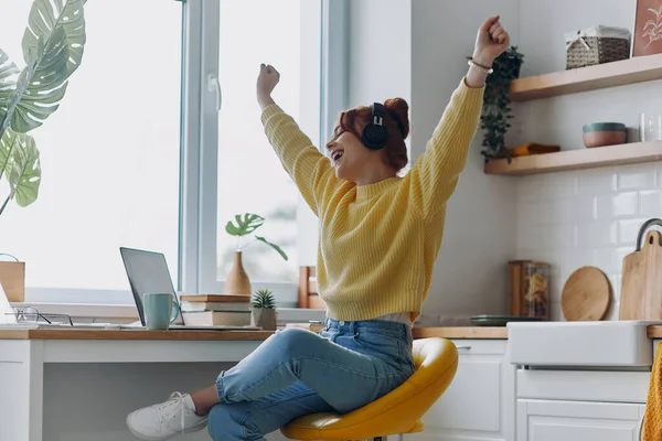 Glad Kvinna Hörlurar Hålla Armarna Upp Medan Sitter Nära Laptop — Stockfoto
